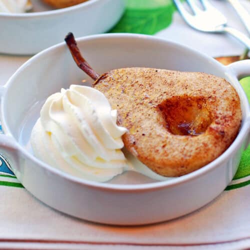 Baked pears are served with whipped cream.