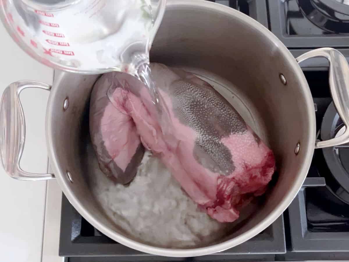 Covering the tongue in water.