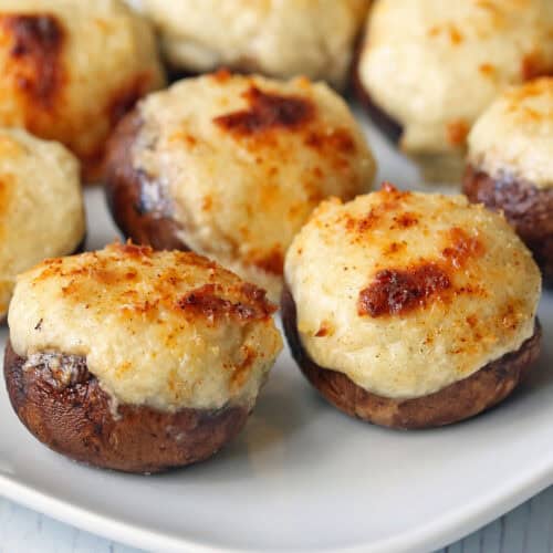 Keto stuffed mushrooms are served on a white plate.