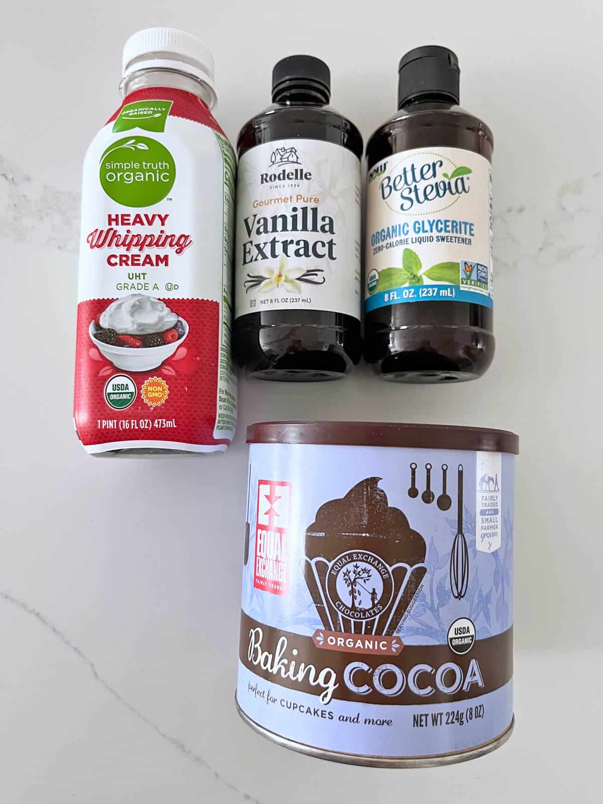 The ingredients needed to make a whipped chocolate topping for keto mini cheesecakes.