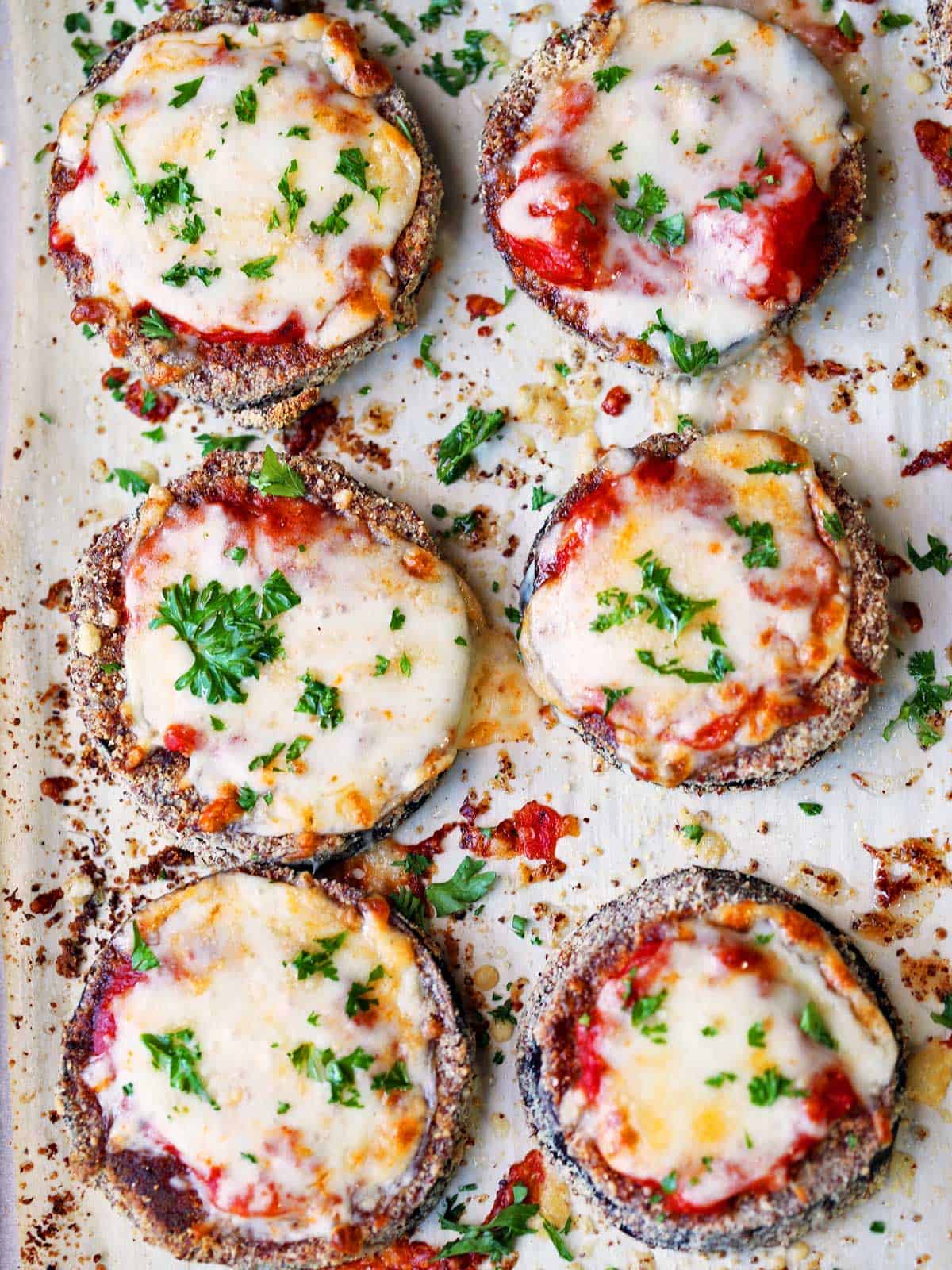Keto eggplant parmesan on a parchment-lined baking sheet.