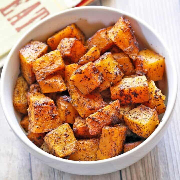 Roasted butternut squash is served in a white bowl.