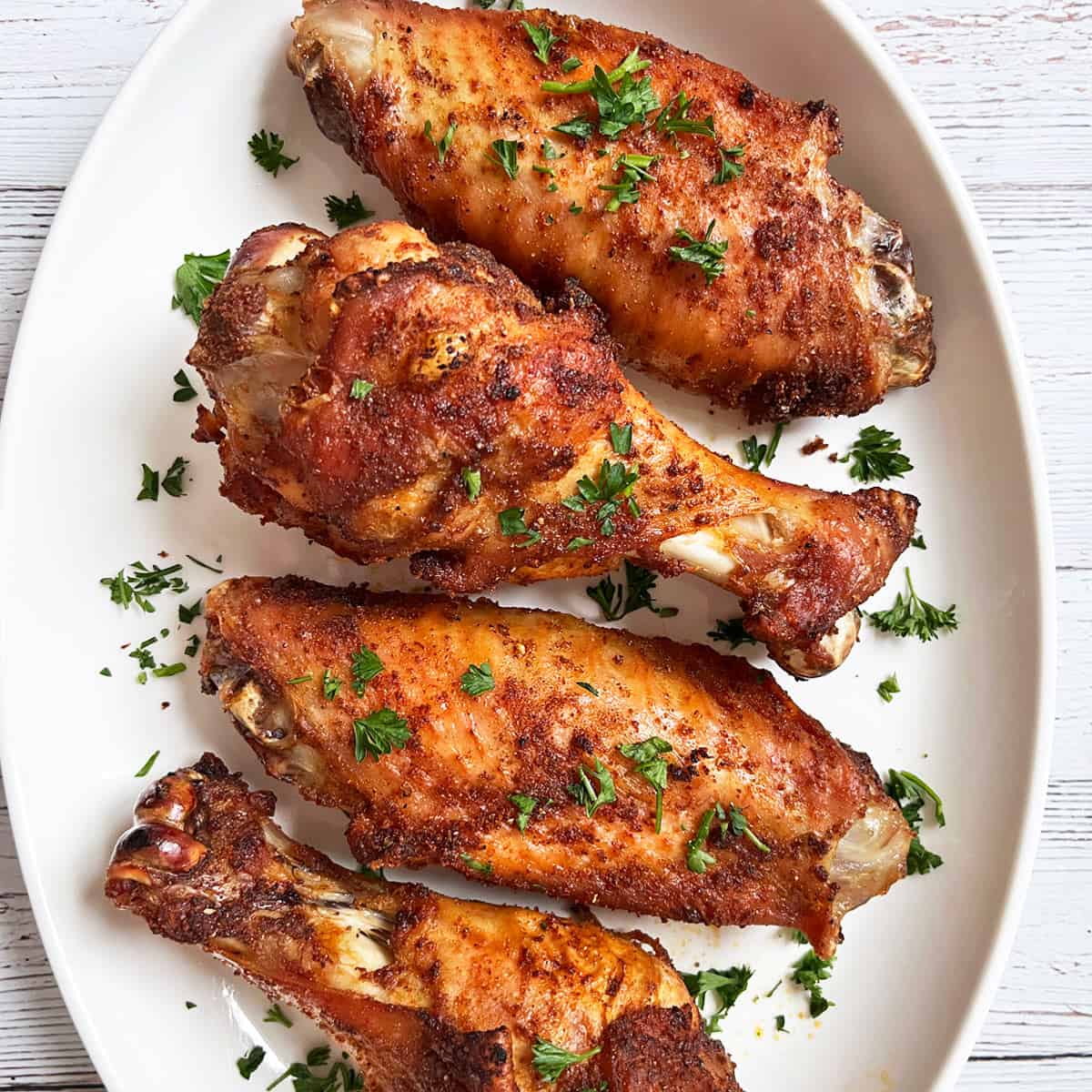 Baked turkey wings are served on a white platter.