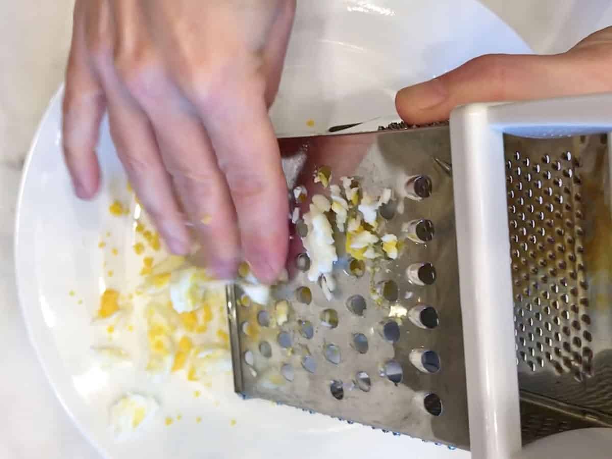 Grating the eggs.