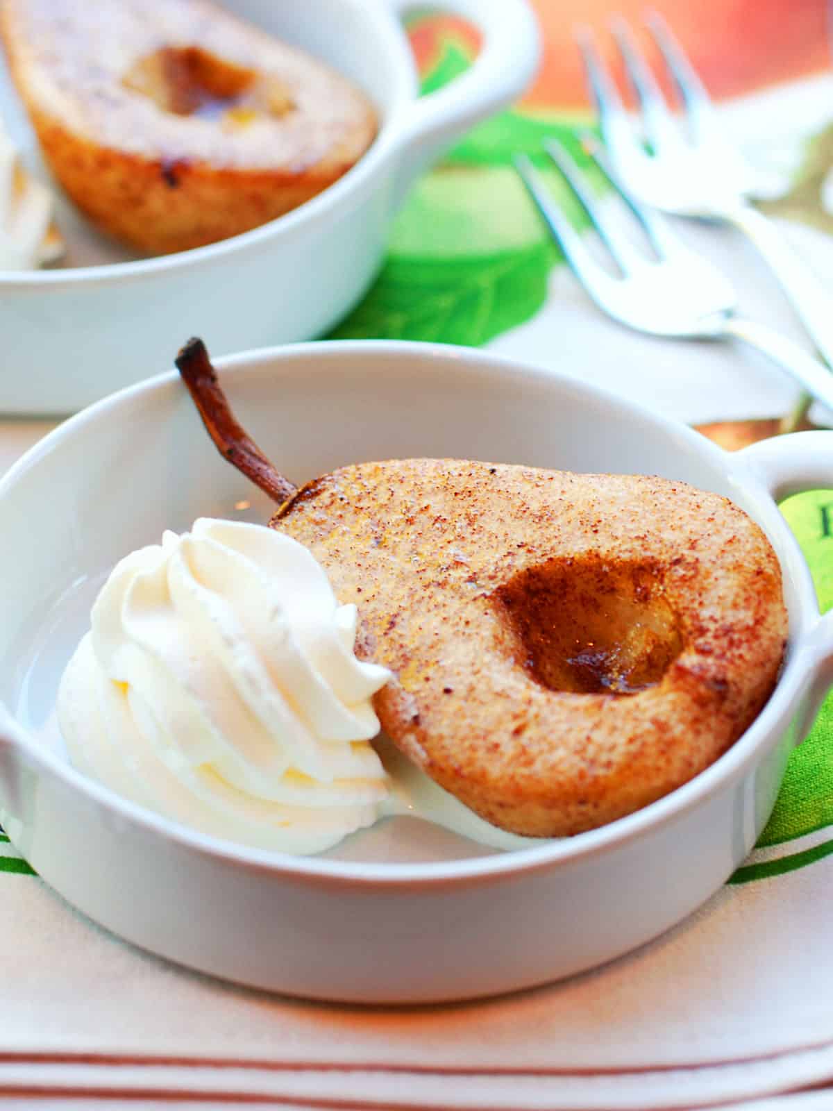 Baked pears are served with whipped cream.