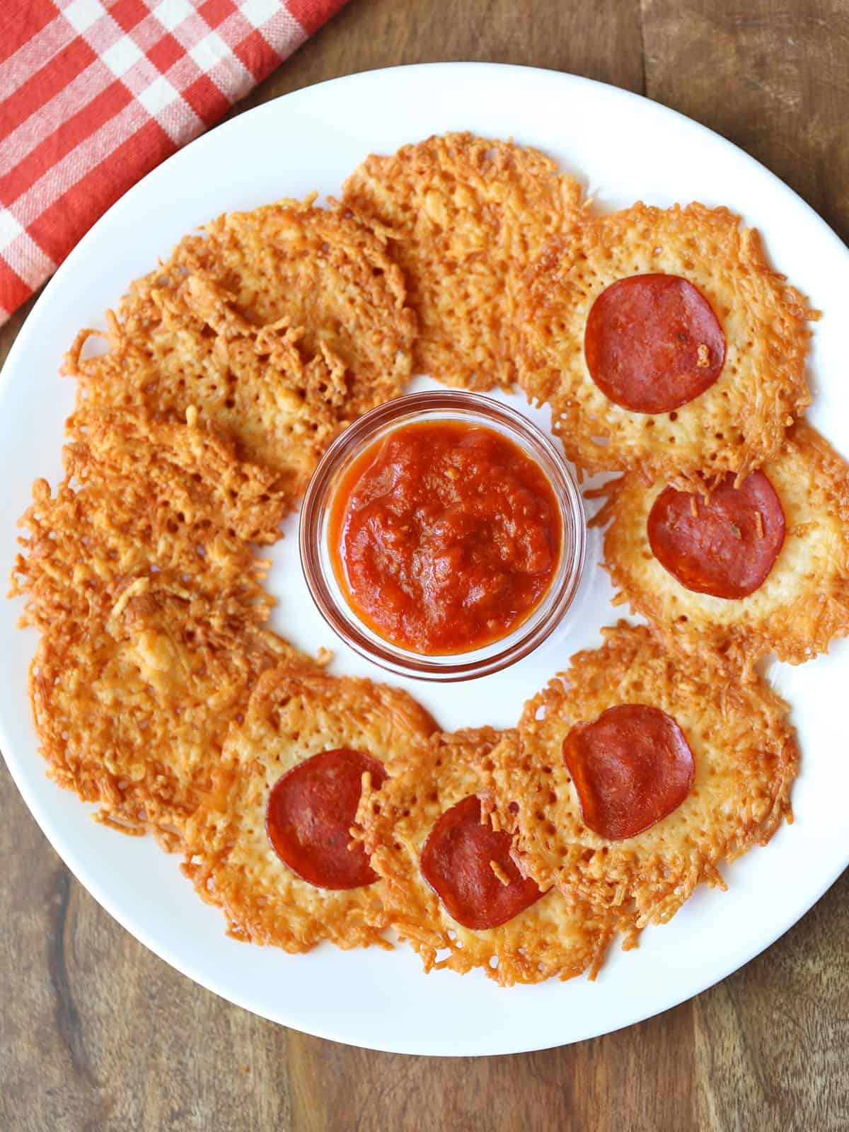 Parmesan crisps are served on a white plate.