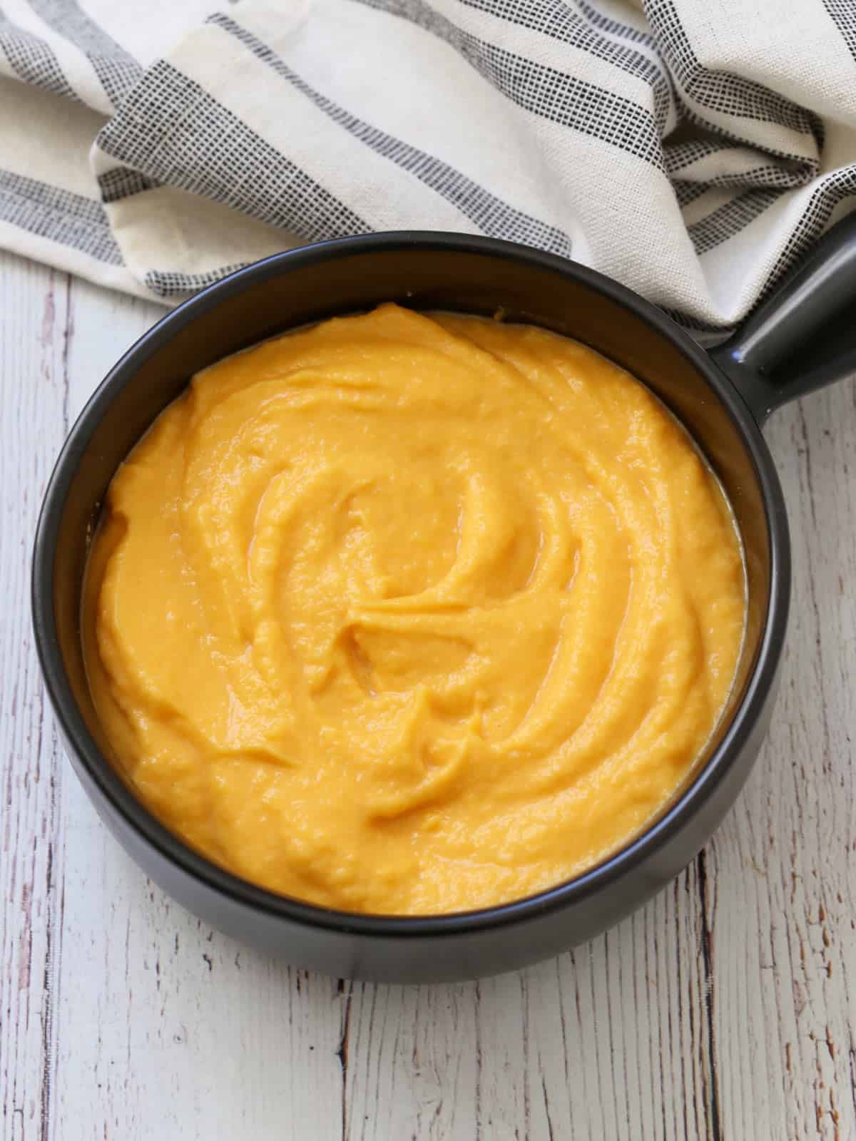 Mashed butternut squash is served in a bowl with a napkin.