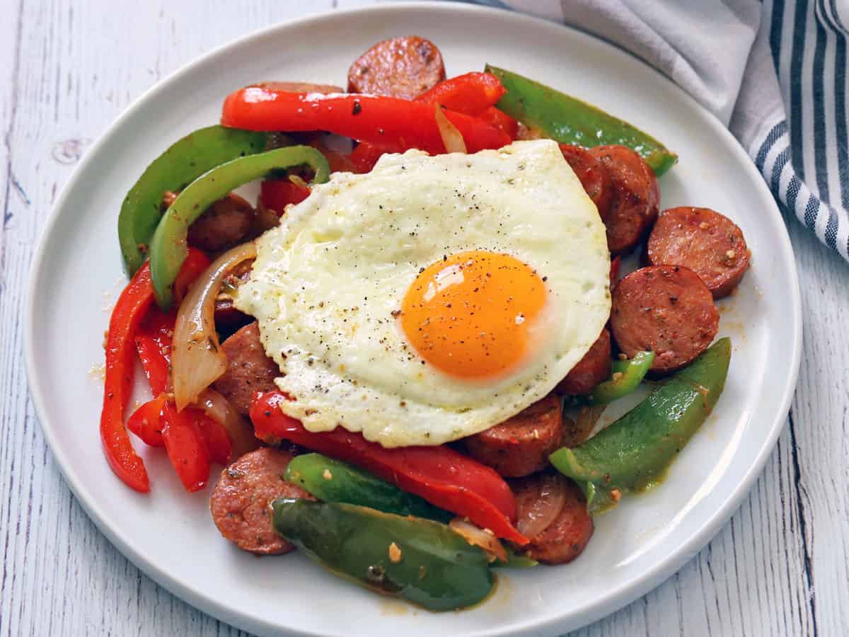 Leftover sausage and peppers are topped with a fried egg.
