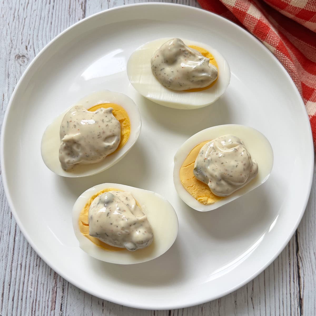 Hard-boiled eggs are topped with tartar sauce.