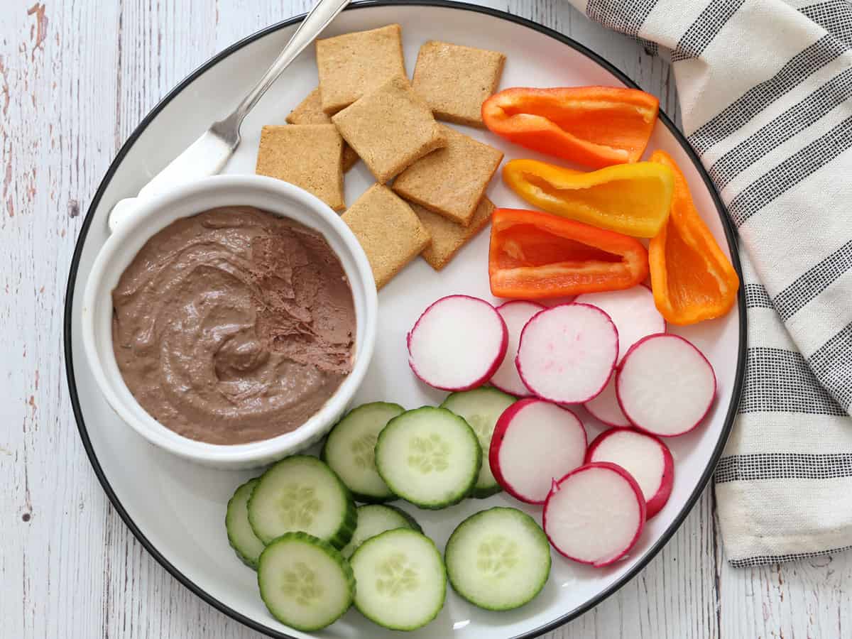 Chicken liver pâté is served with veggies and crackers.