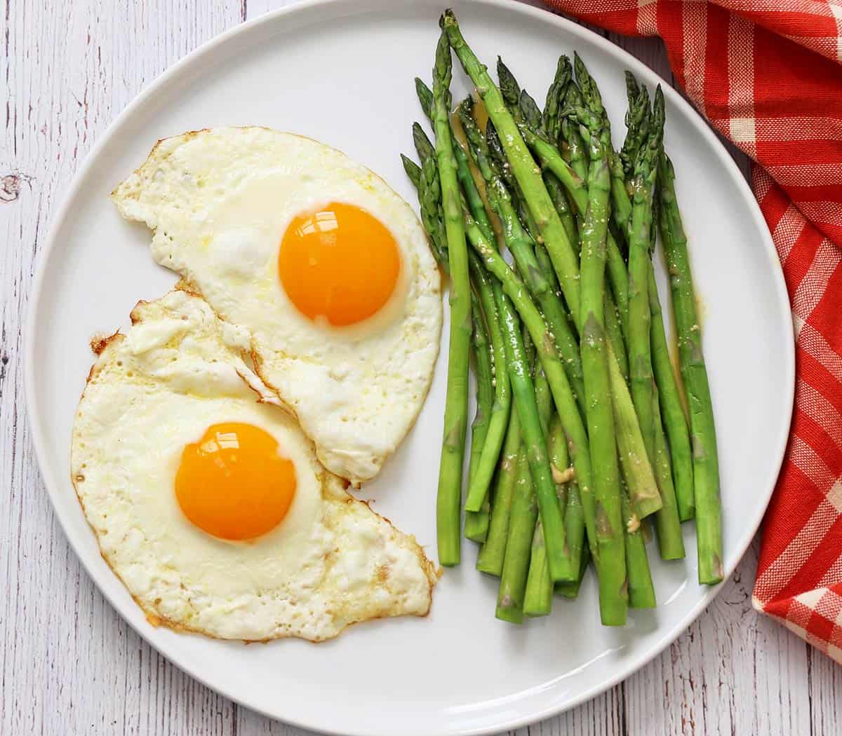 Microwave asparagus is served with fried eggs.