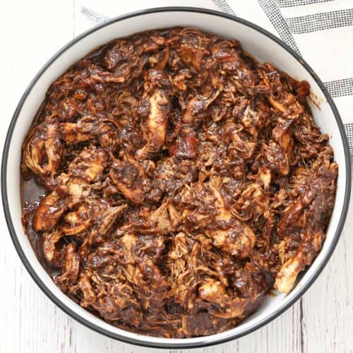 Pulled chicken is served in a white bowl.