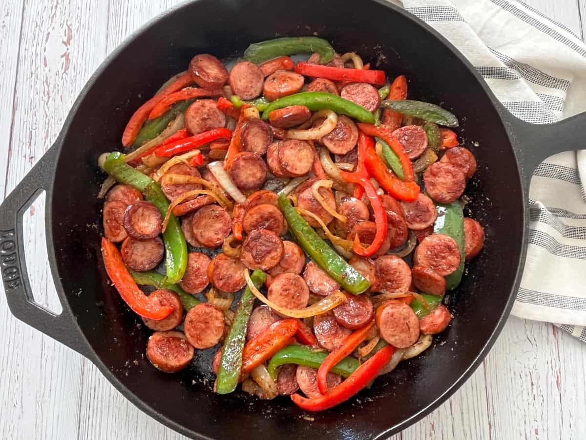 Sausage and peppers in a cast-iron skillet.