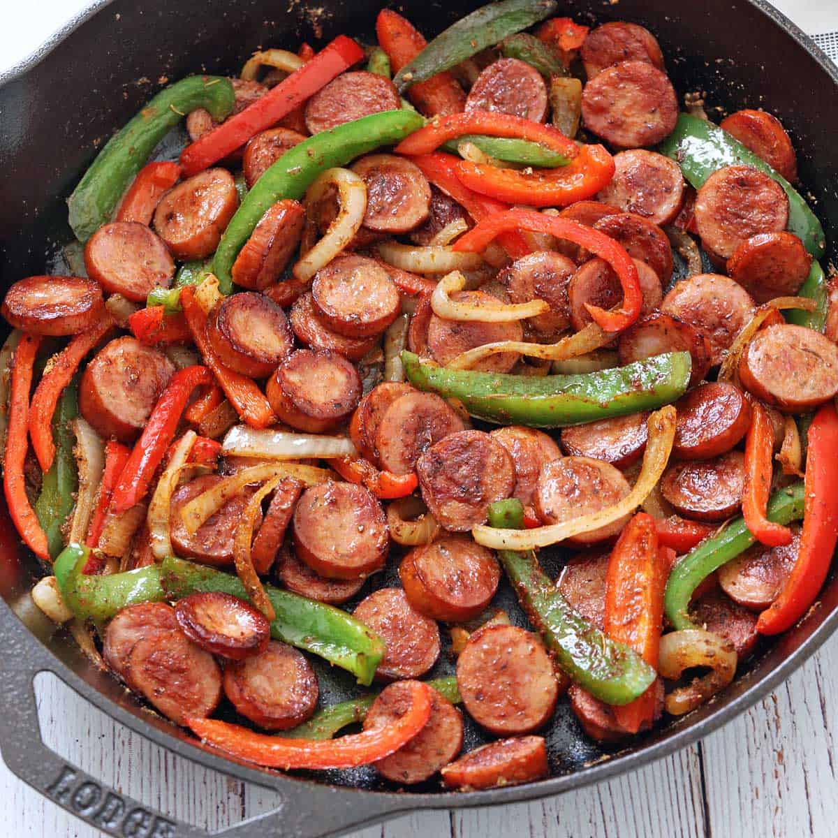 Sausage and peppers are served in a cast-iron skillet.