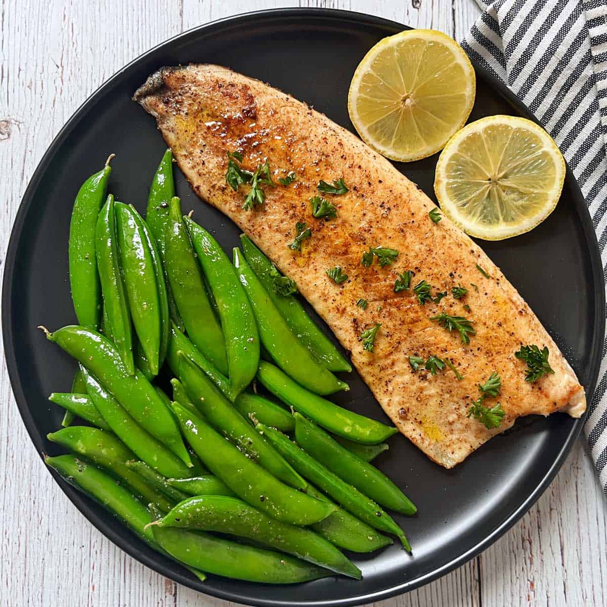 Sugar snap peas are served with pan-fried rainbow trout.