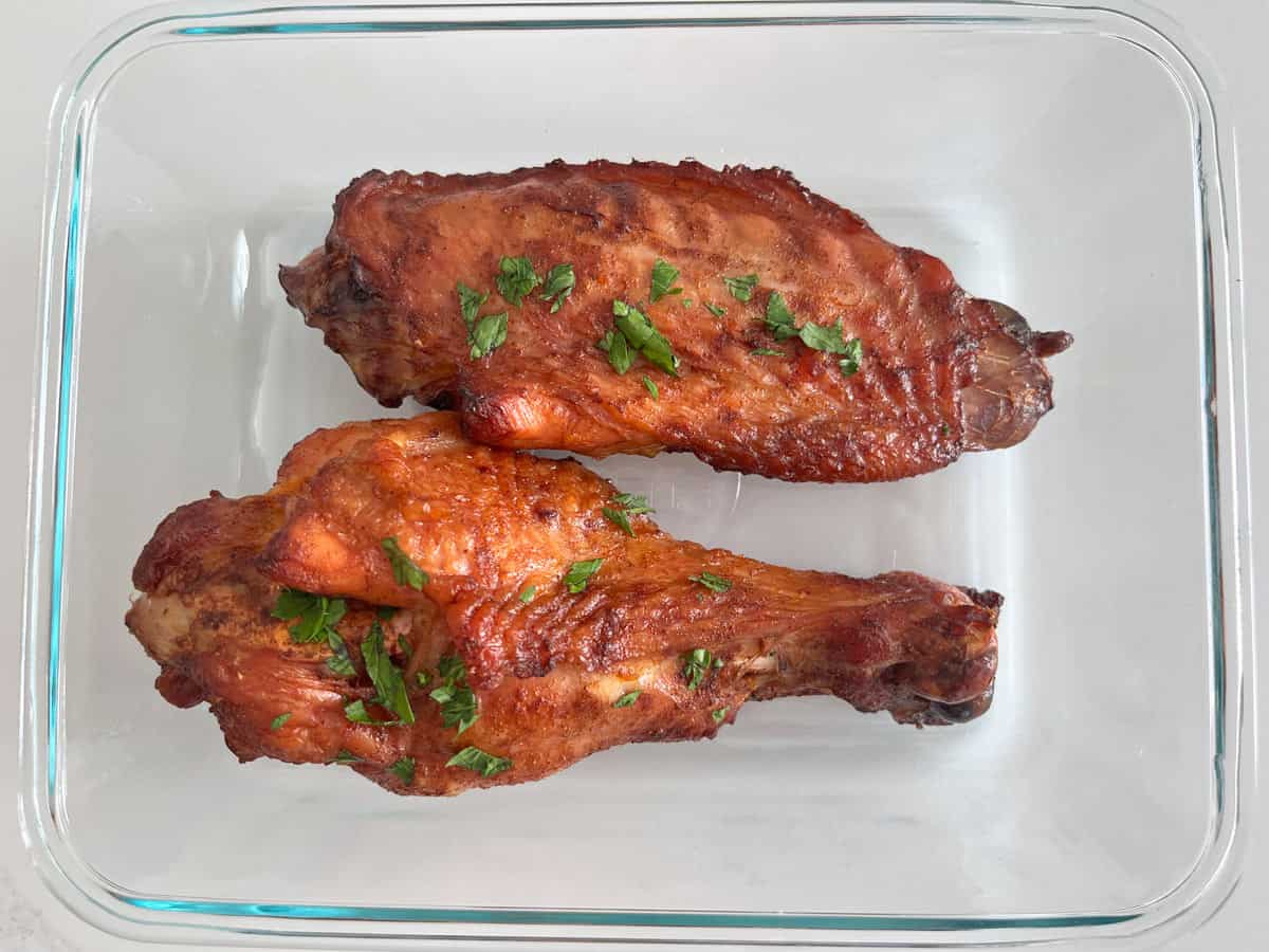 Leftover turkey wings are stored in a glass container.