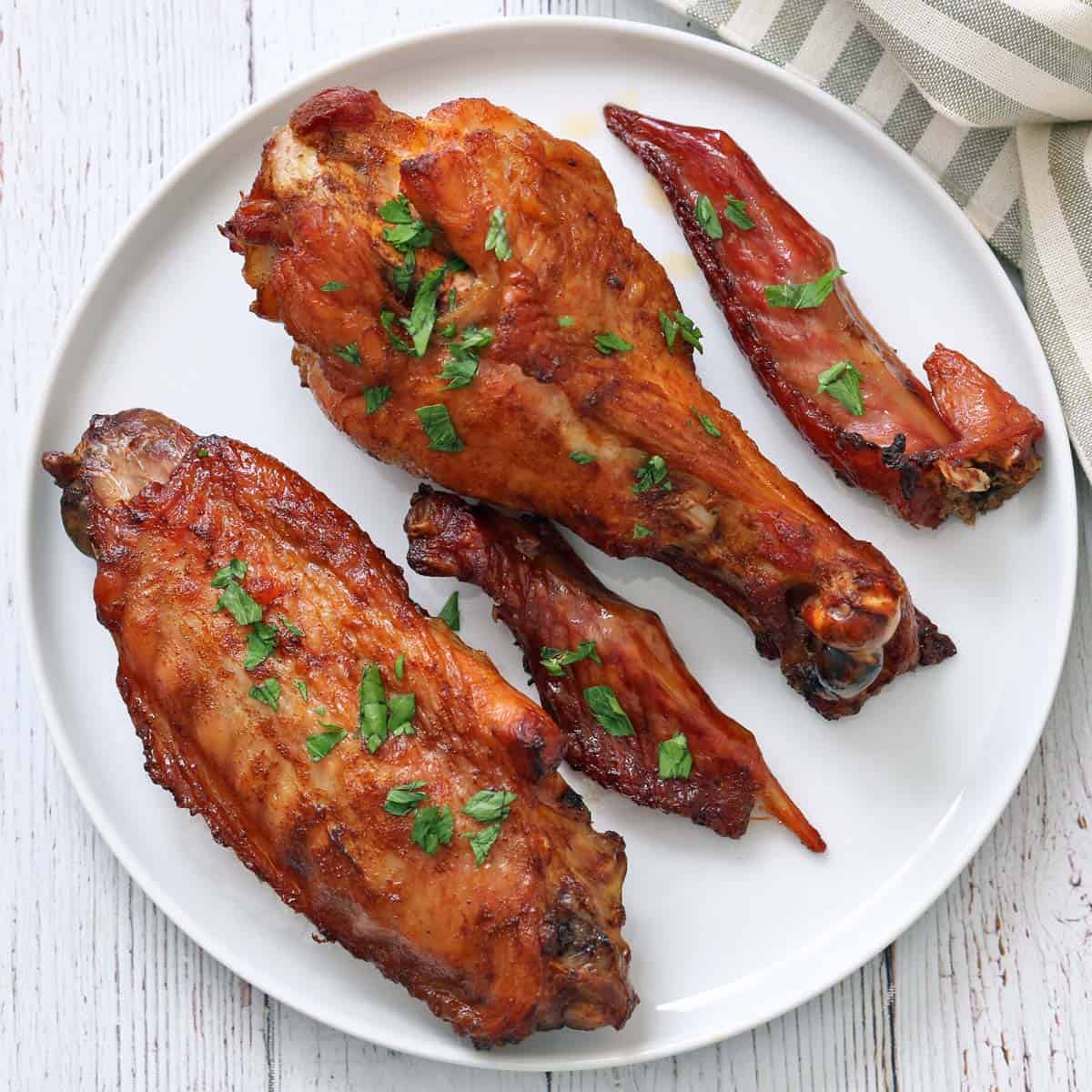 Turkey wing tips are served on a plate alongside the wings.
