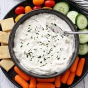Greek yogurt dip is served with crackers and veggies.