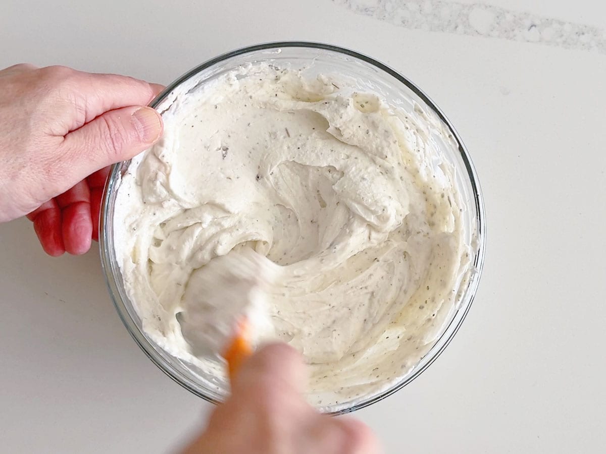 Mixing the dip with a rubber spatula.
