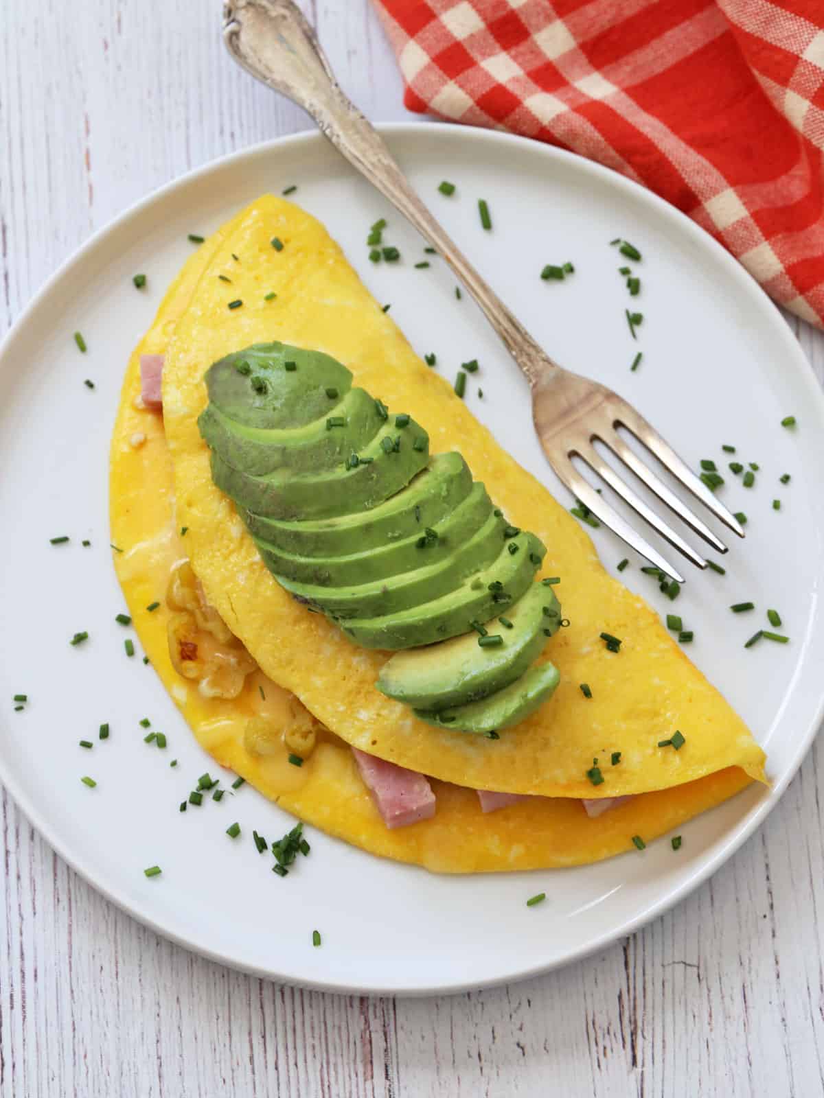 An omelette is topped with avocado.