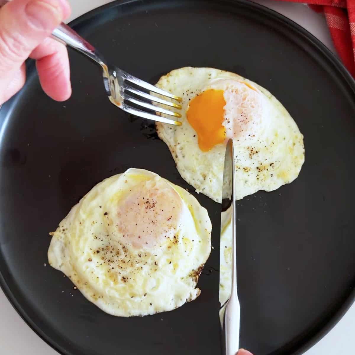 Over easy eggs on a plate.