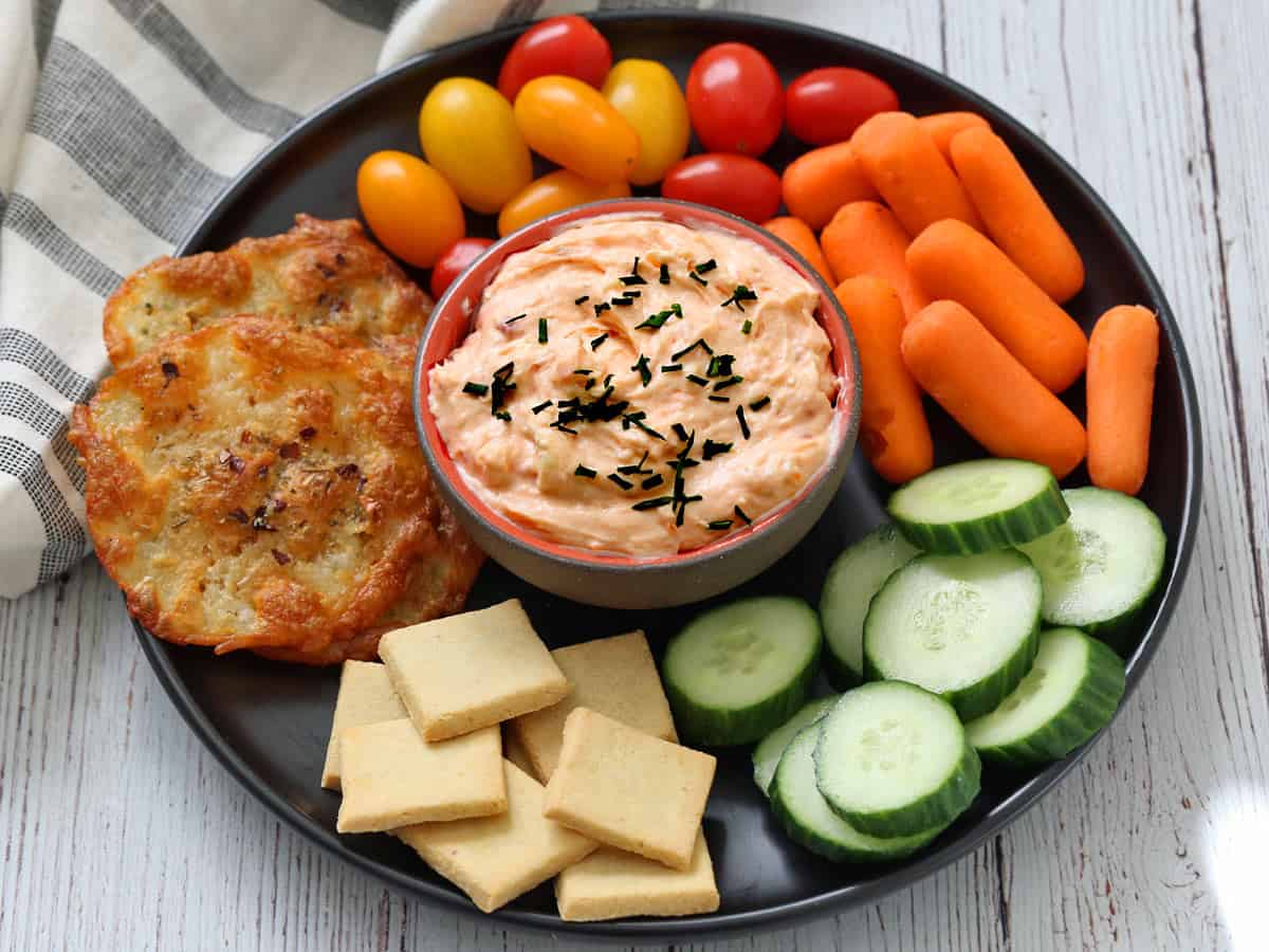 Salmon mousse is served with veggies and crackers.