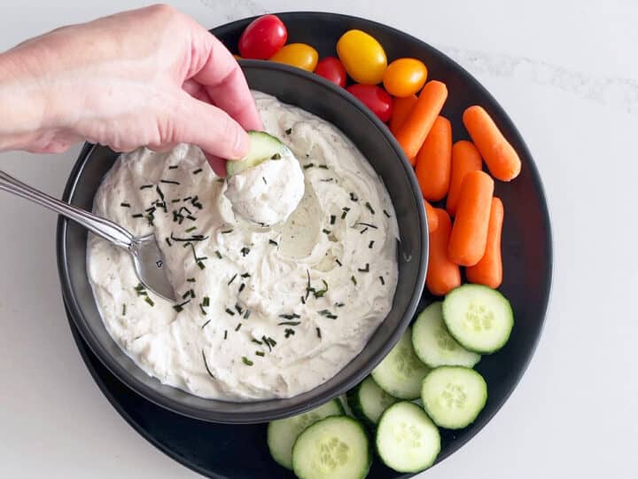 Scooping the dip with a cucumber slice.