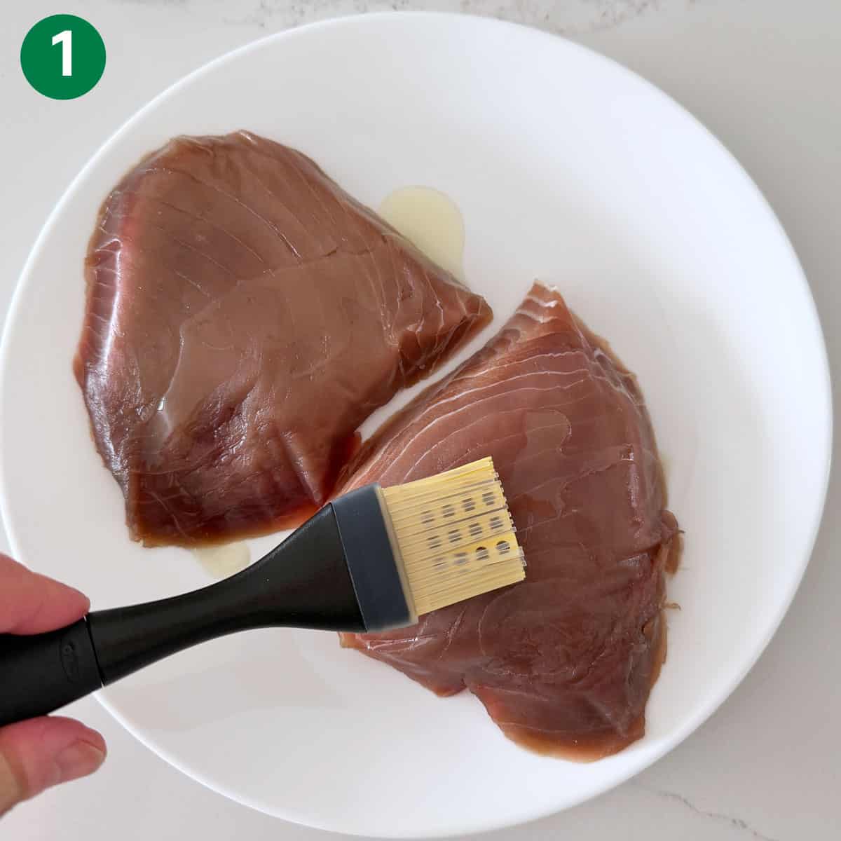 Coating the tuna steaks with oil.