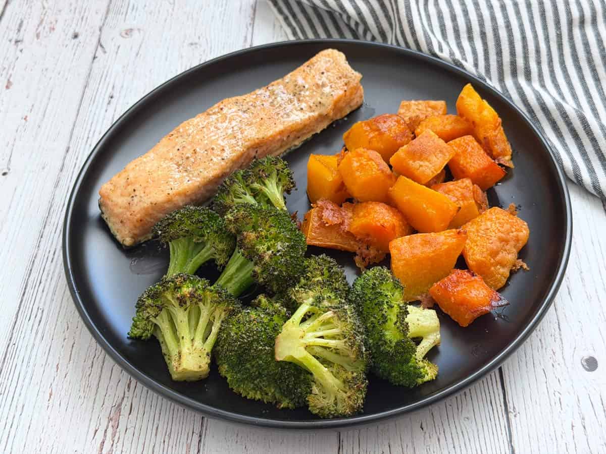 Butternut squash, broccoli, and salmon on a plate.