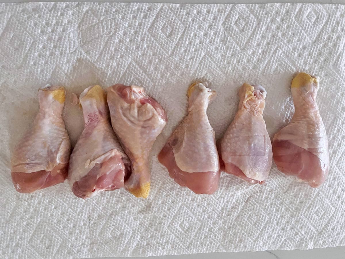 Blotting the drumsticks with paper towels.