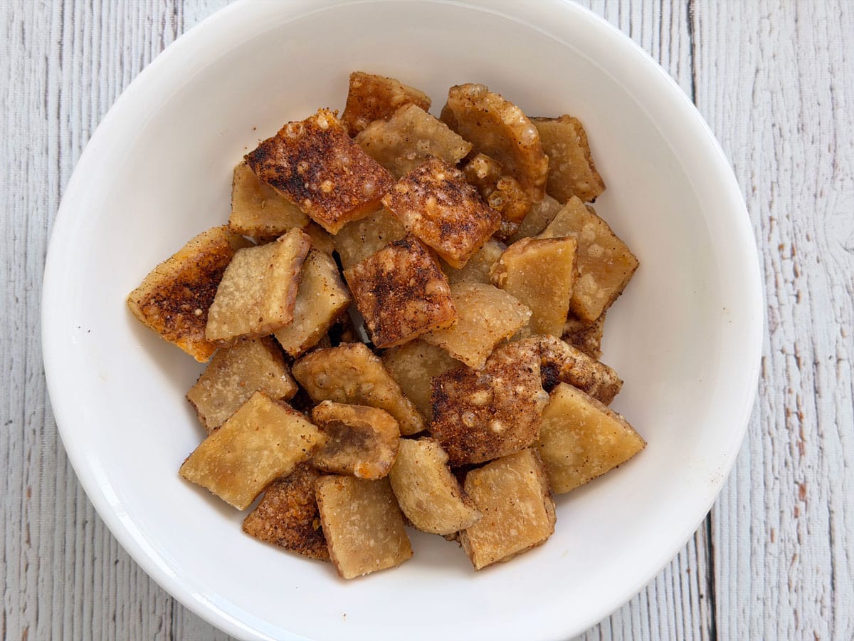 Pork rinds in a white bowl.