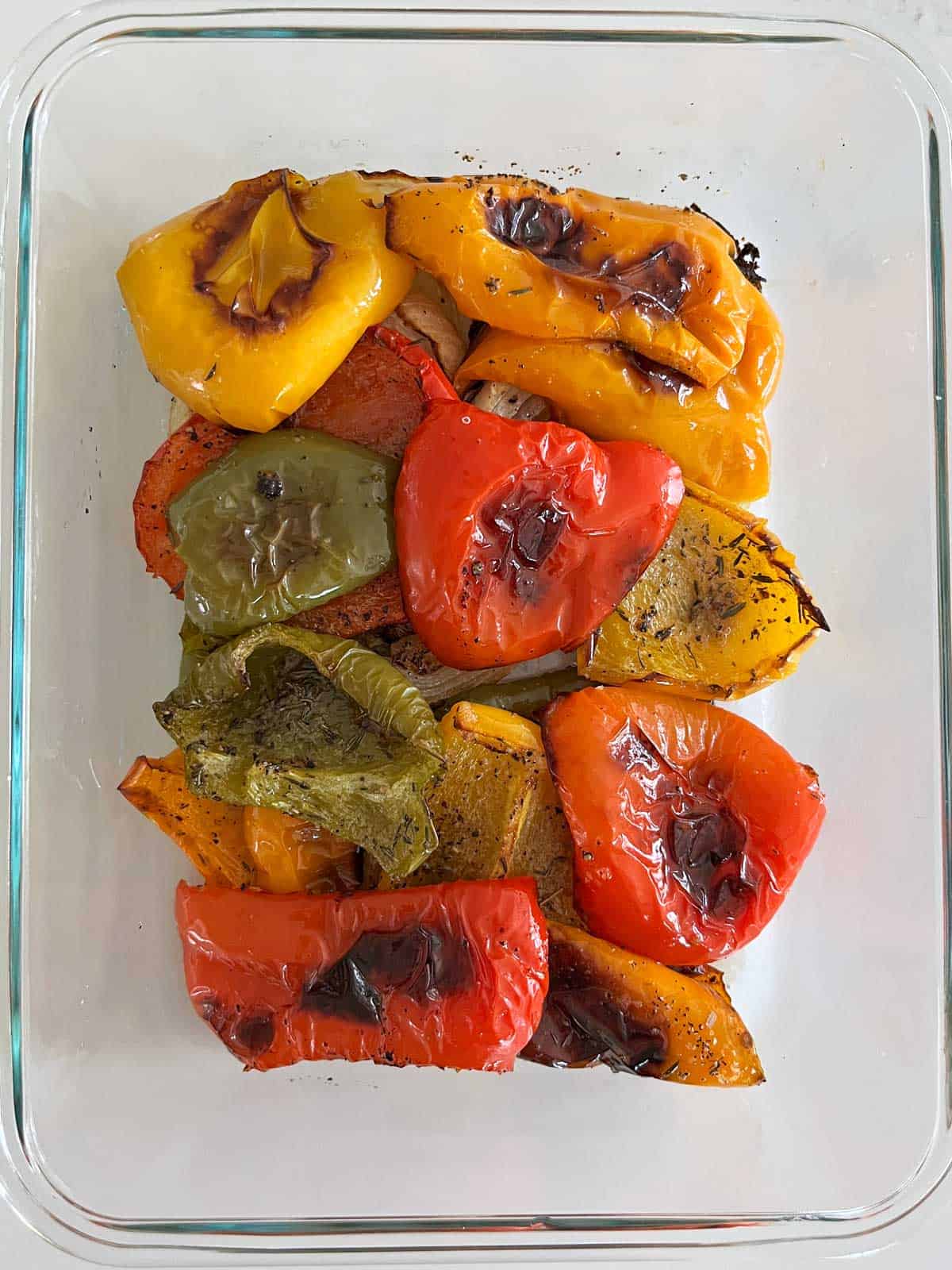 Roasted peppers are stored in a glass container.