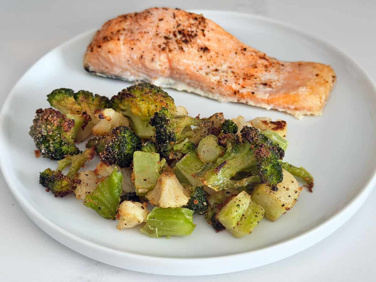 Roasted frozen cauliflower and broccoli are served with baked salmon.