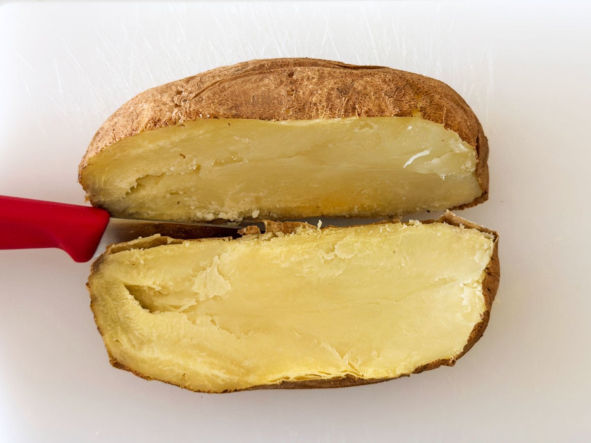 Cutting a microwave potato with a knife.