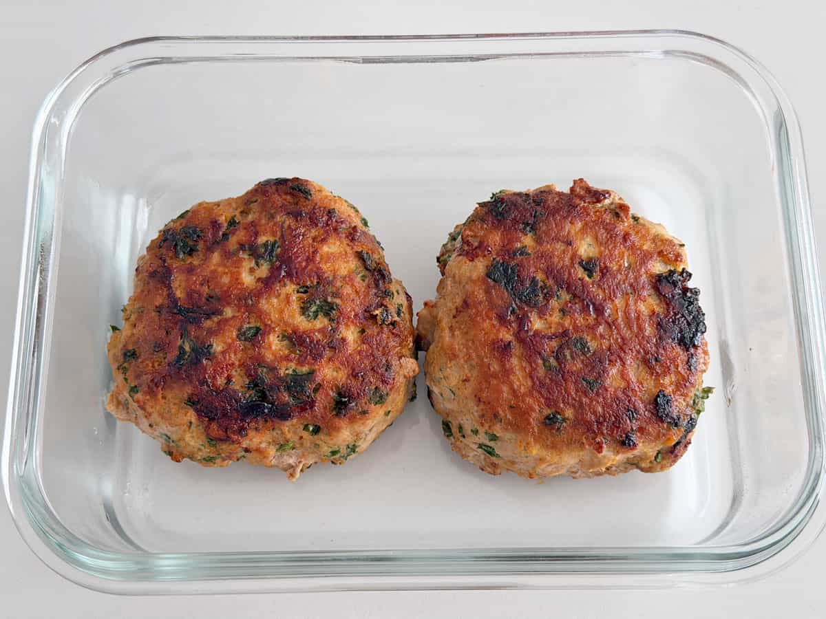 Turkey burgers leftovers are stored in a glass container.