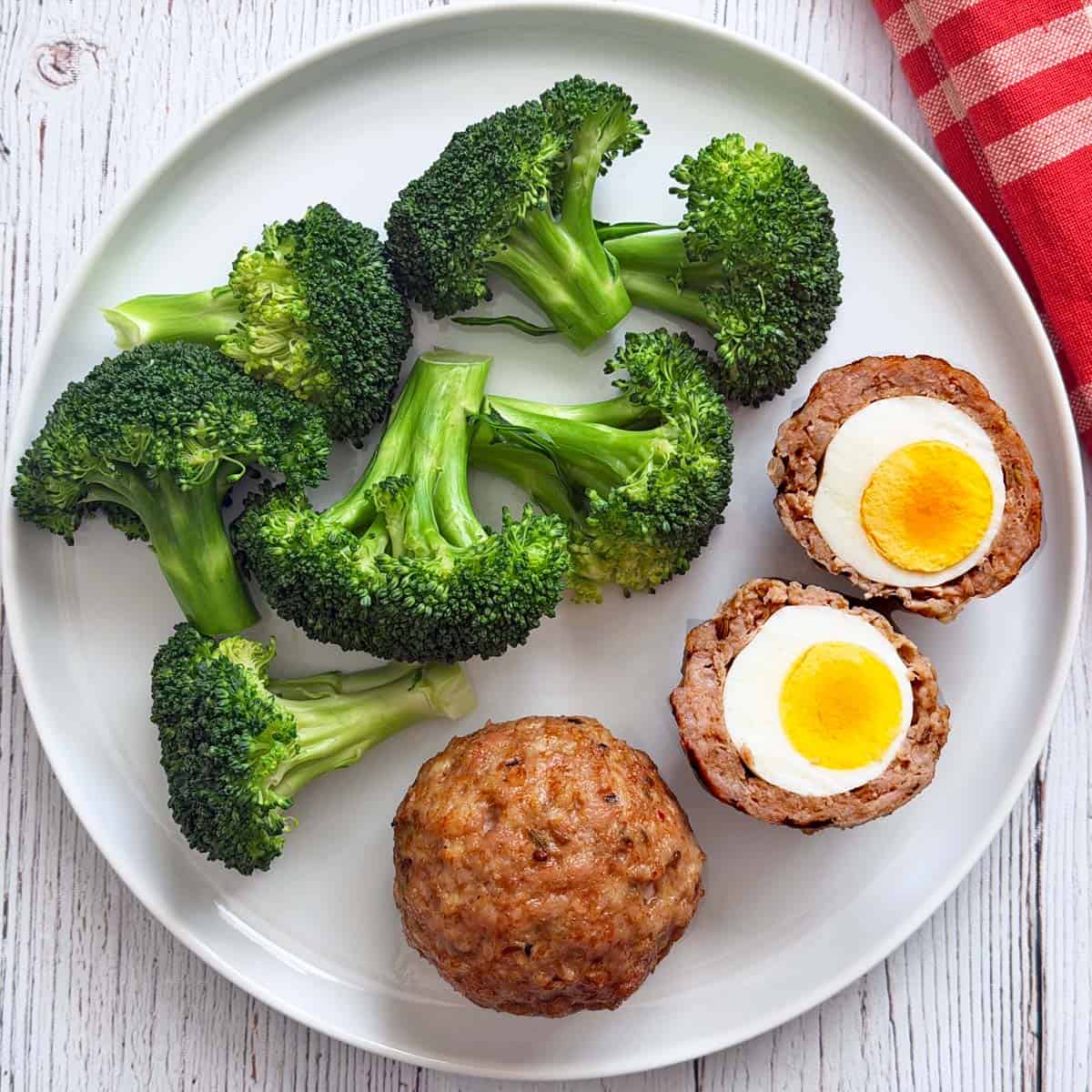 Scotch eggs are served with broccoli.