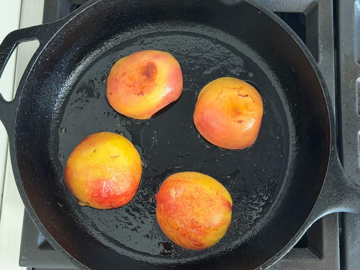 Cooking peaches in a cast-iron skillet.
