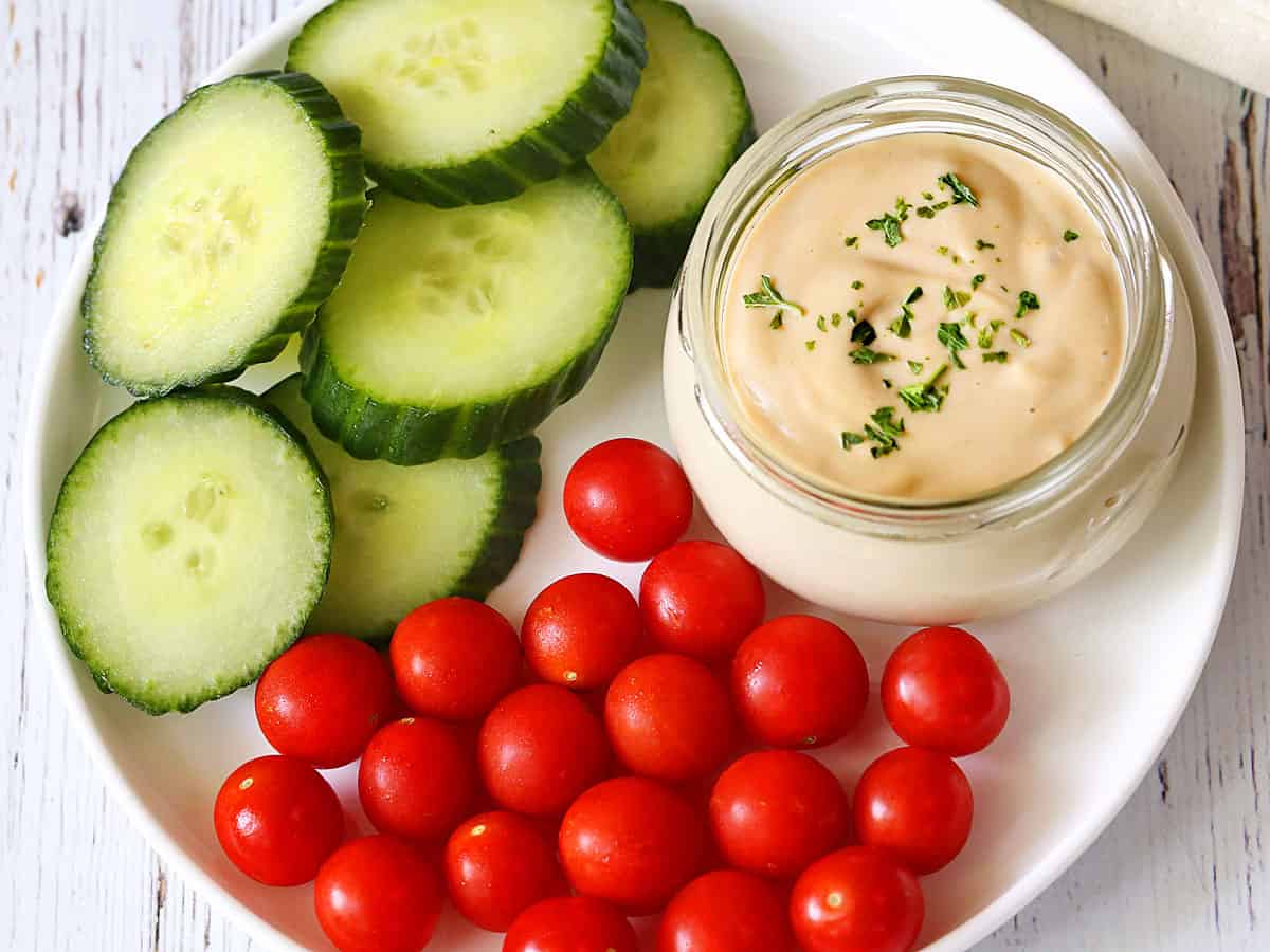 Tahini sauce is served with fresh-cut veggies.
