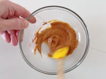 Mixing Dijon mustard and spices in a bowl.