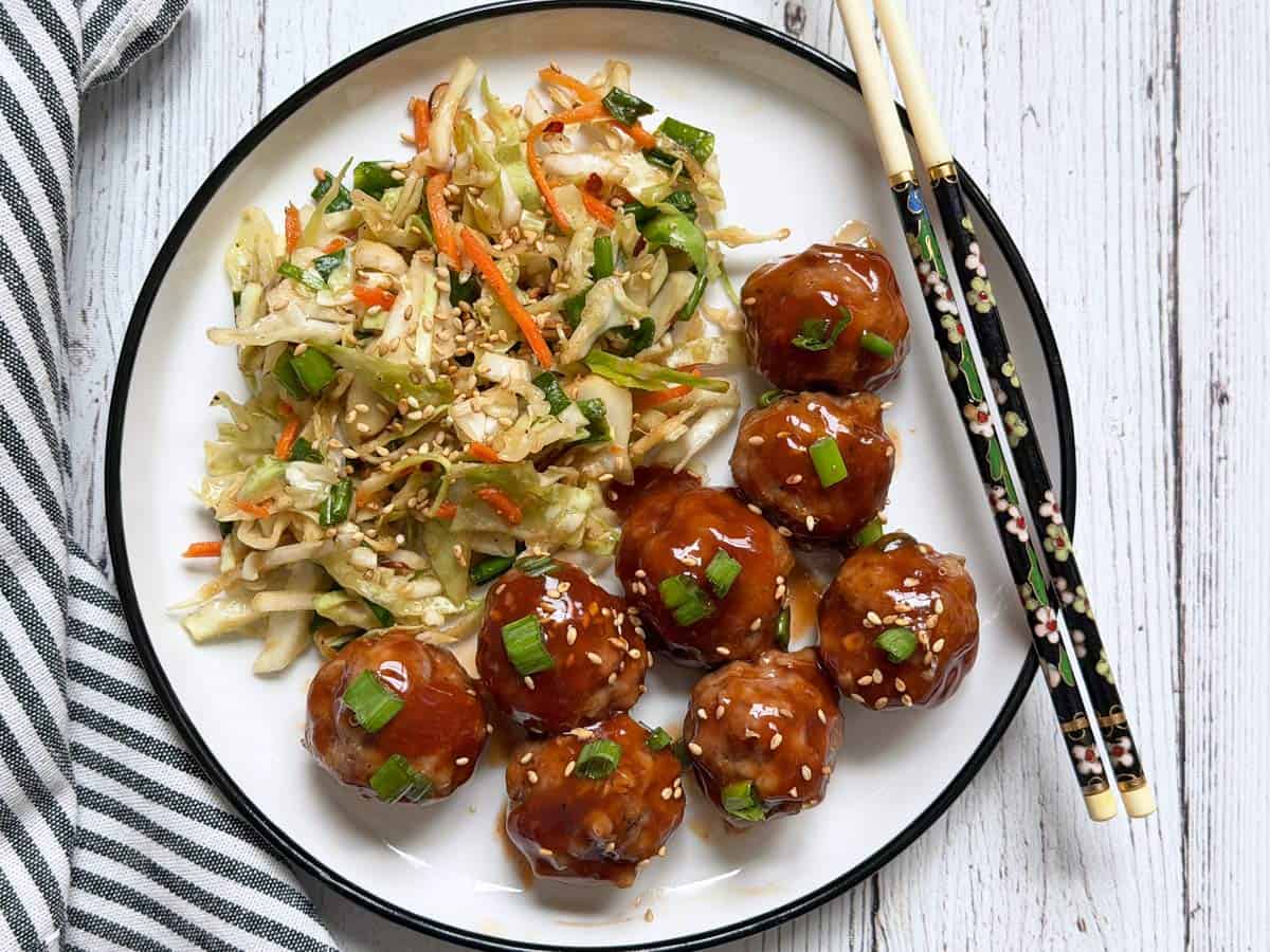 Asian cabbage salad is served with meatballs.