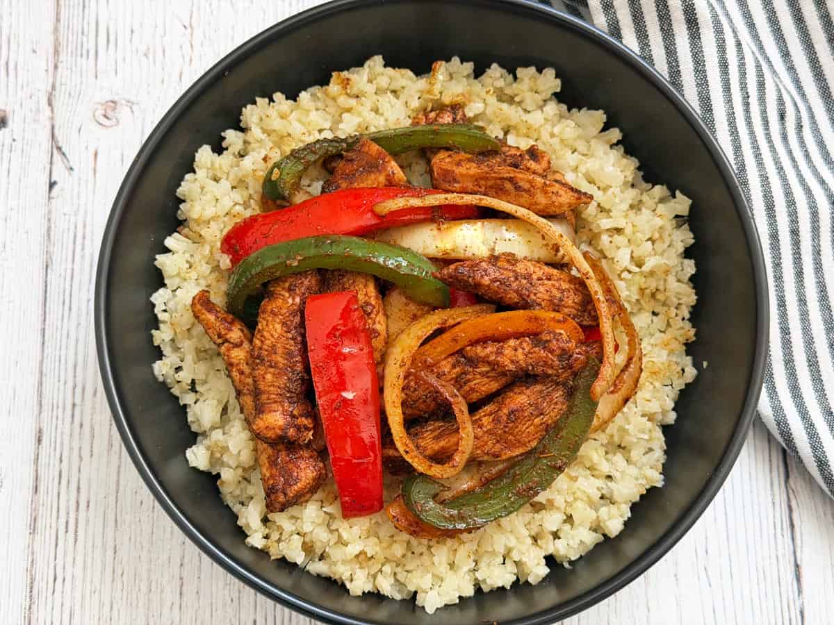 Chicken fajitas are served over cauliflower rice.