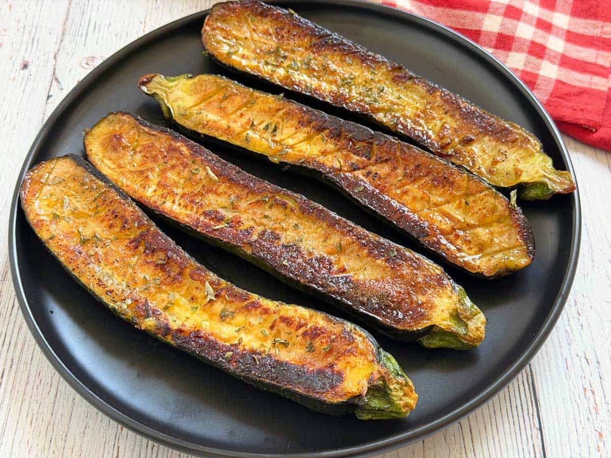 4 slices of roasted zucchini are served on a plate.