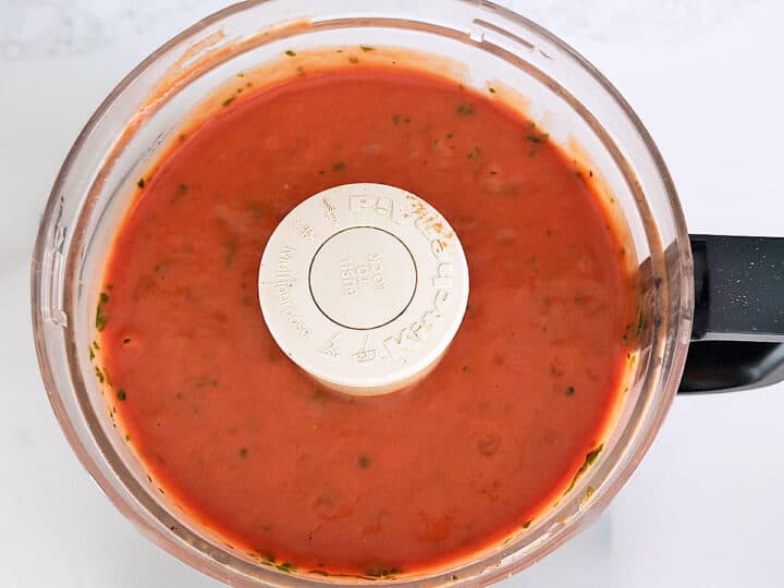 Chilled tomato soup is ready in the food processor bowl.