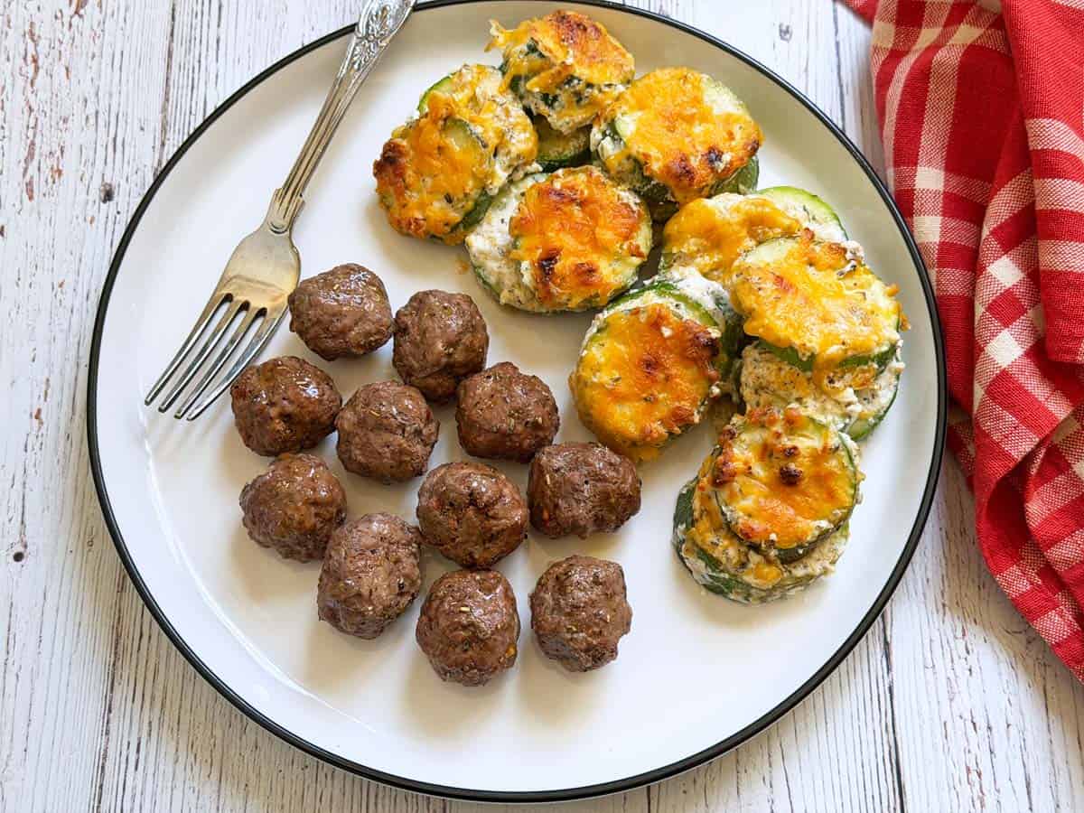 Zucchini casserole is served with meatballs.