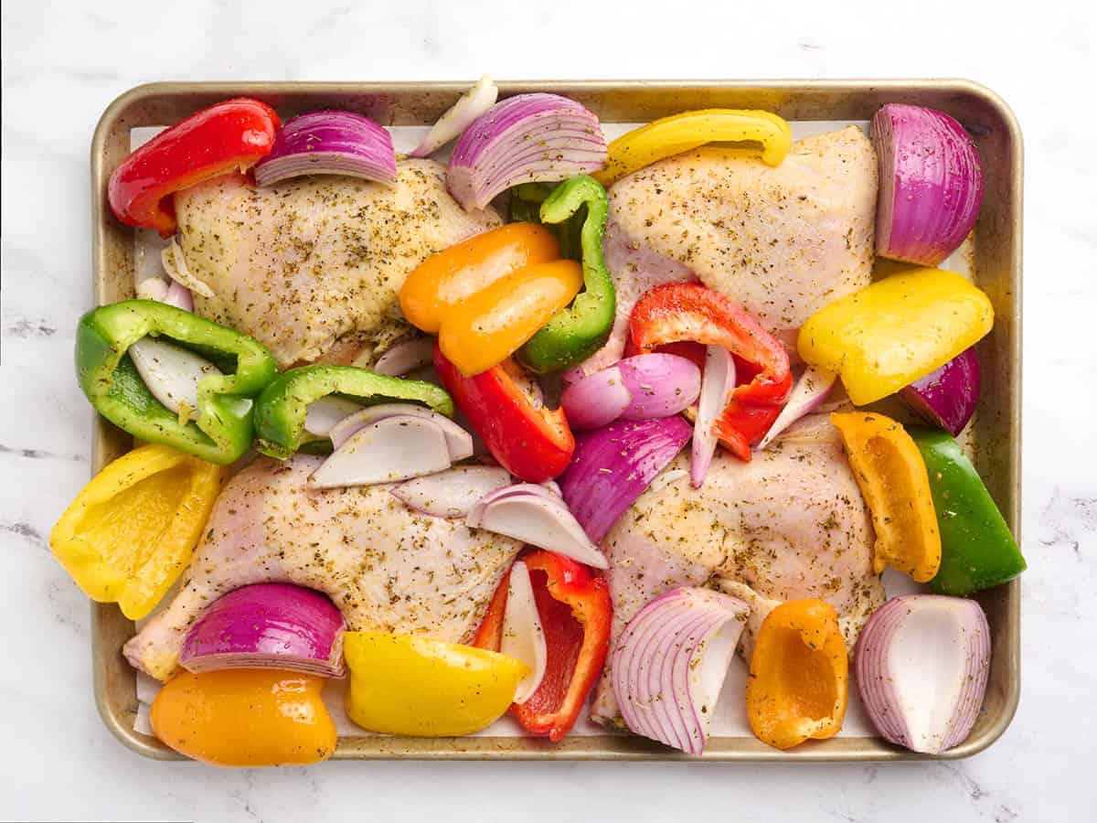 The chicken and veggies are ready to roast in the pan.