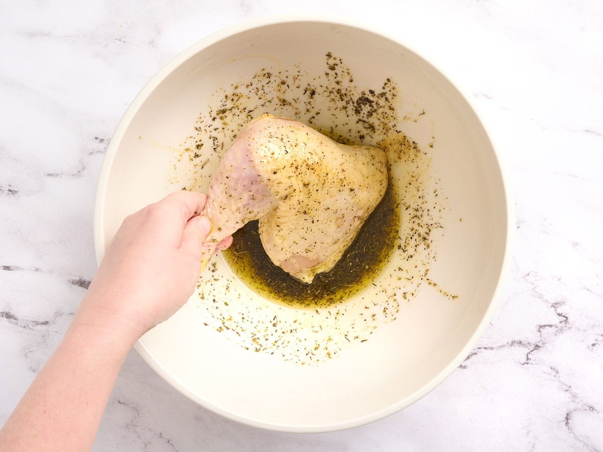 The chicken is coated in herbs and oil.
