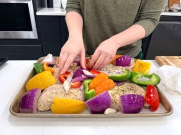 Nestling the vegetables between the chicken pieces.