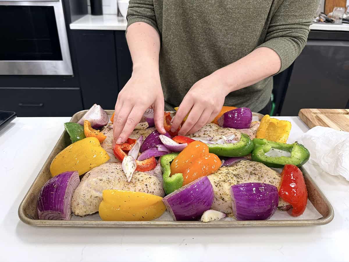 Nestling the vegetables between the chicken pieces.