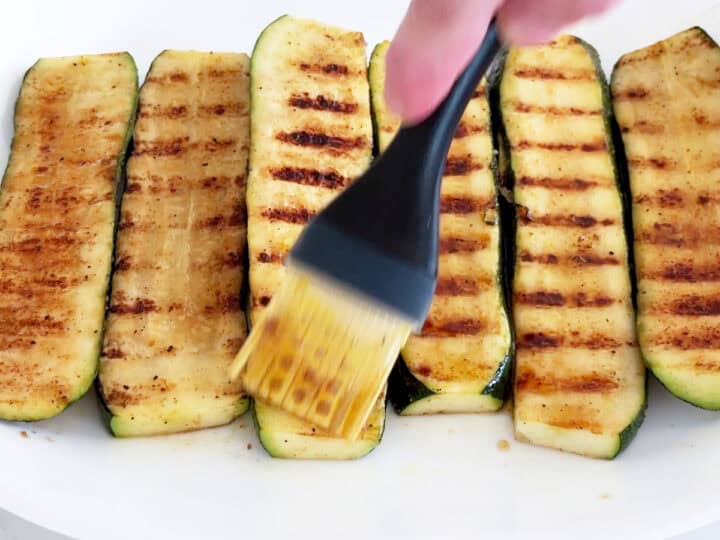 Brushing the grilled zucchini with more marinade.