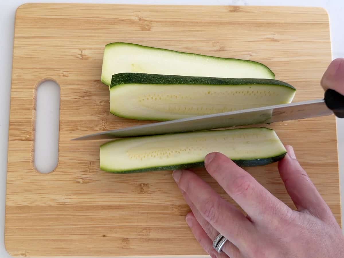 Slicing the zucchini lengthwise.